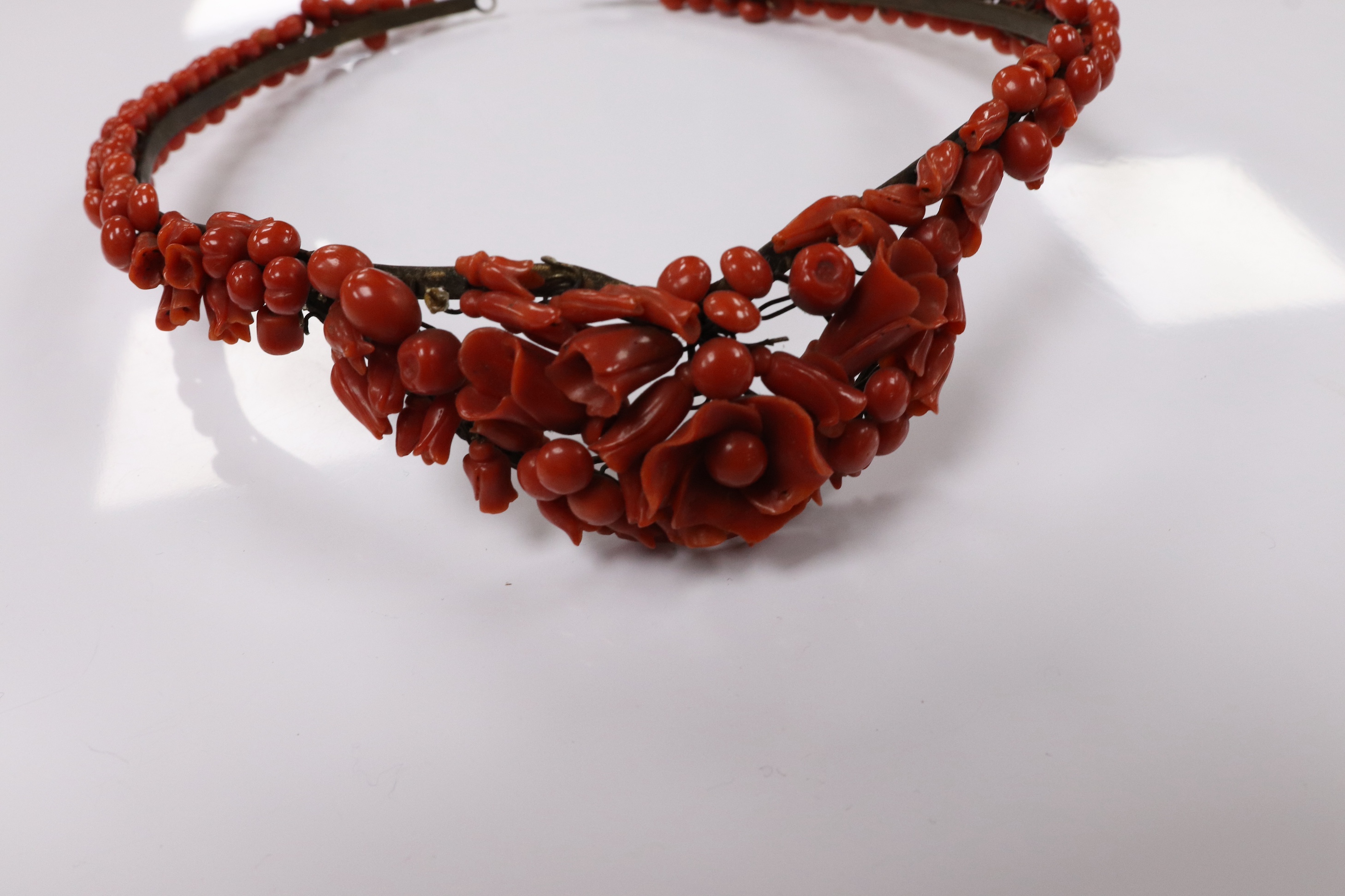 A 19th century base metal and coral bead floral designed tiara, approximately 40cm. Condition - poor to fair (some coral detached pieces in a small bag)